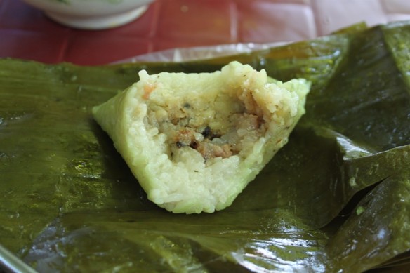 steamed sticky rice w pork in banana leave half eaten